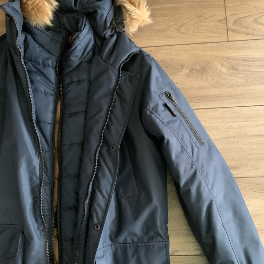 Navy blue jacket with inside pocket and arm pocket.